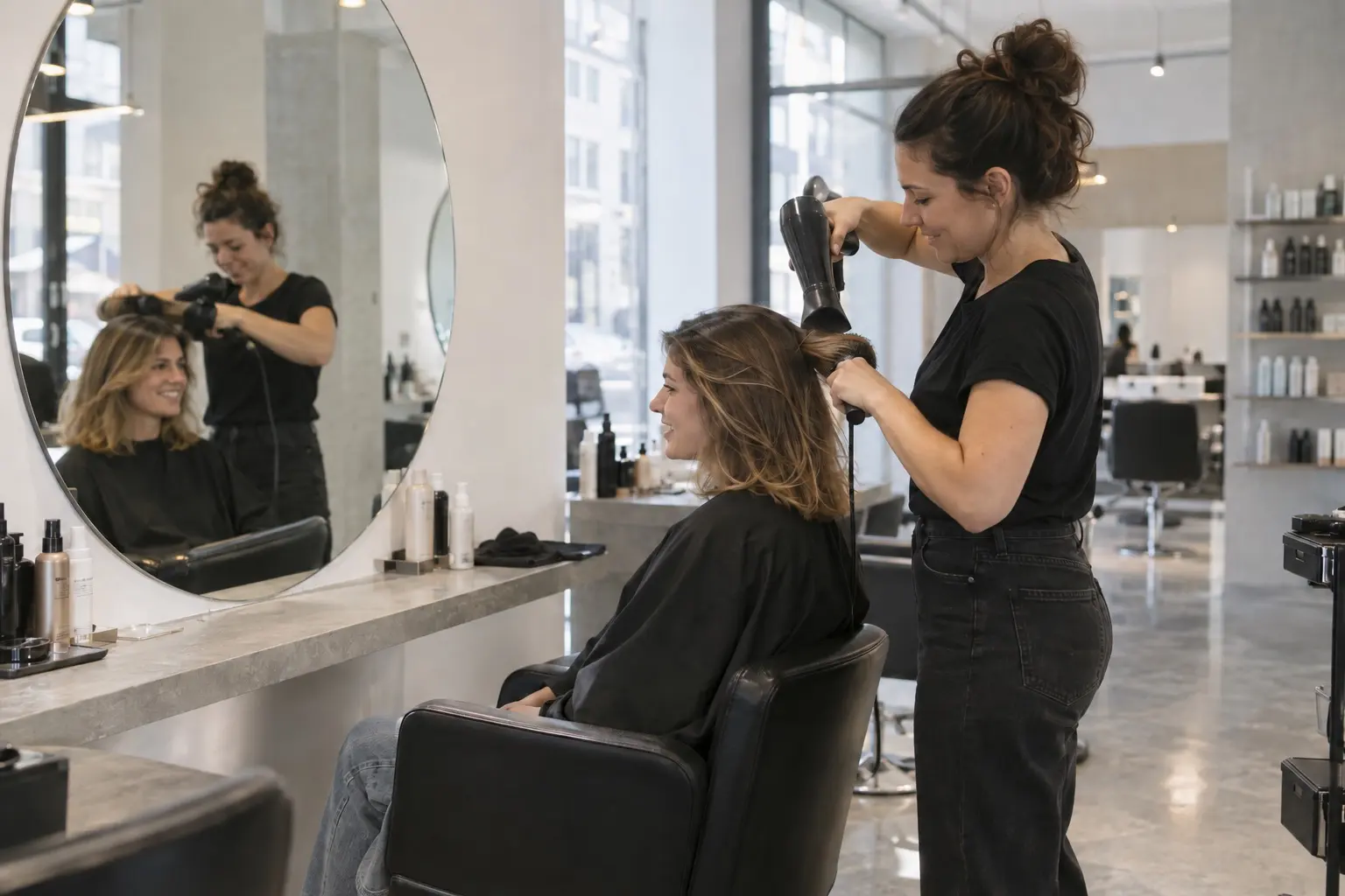 Kapster föhnt het haar van een klant in een moderne salon